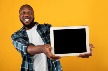 Joyful African Man Showing Empty Digital Tablet Screen, Yellow Background