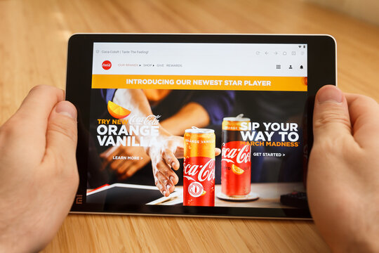 SAN FRANCISCO, US - 1 April 2019: Close up to hands holding tablet using internet and looking through Coca-cola web site, in San Francisco, California, USA. An illustrative editorial image.
