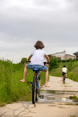 Child, boy, riding bike in muddy puddle, summer time