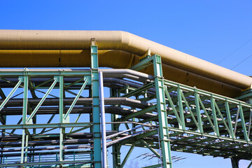 Low angle view on steel pipeline construction against blue sky