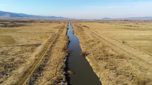 Drone camera flying over dirty Olt river in Romania.
