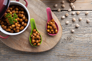 Vegan grilled chickpeas. Homemade vegan chickpeas, Crispy roasted organic chickpeas . Served as a snack in a bowl, on a wooden table top.