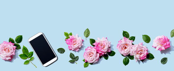 Smartphone with pink roses overhead view - flat lay