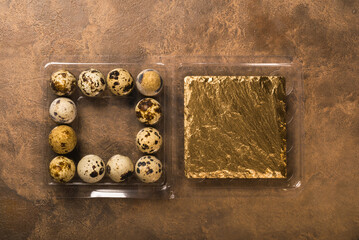 Many quail eggs in plastic packaging on brown background. Copy space.