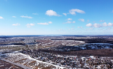 Top view of a spring field with snow and blue sky during the day