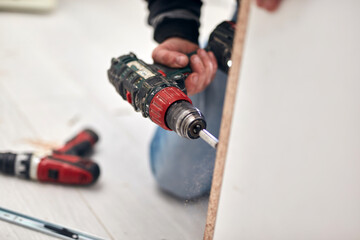 Handyman worker assembling furniture and fixing it.