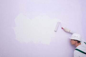 a worker looks at a white, unpainted ad space