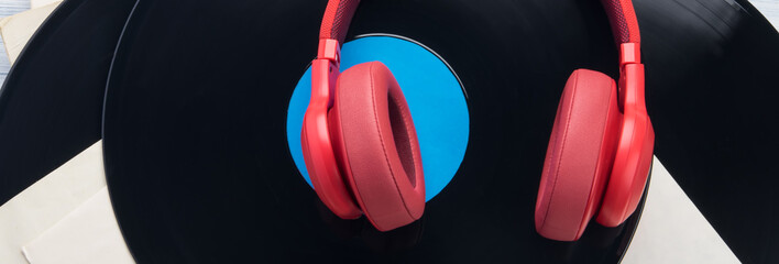 red studio headphones, lying on the background of retro vinyl records