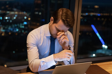 Fototapeta premium Close up exhausted sleepy businessman using laptop, working at night, taking off glasses, suffering from eye strain, tired overworked employee executive finishing project, deadline concept