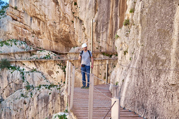 Man filming the Caminito Del Rey - mountain wooden path along steep cliffs in Andalusia, Spain