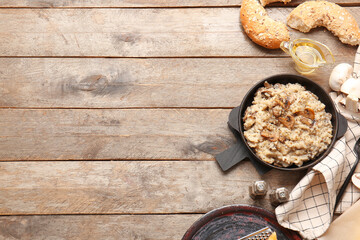 Frying pan with tasty risotto on wooden background