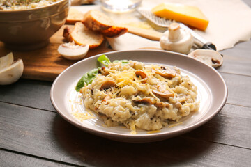 Plate with tasty risotto on dark wooden background