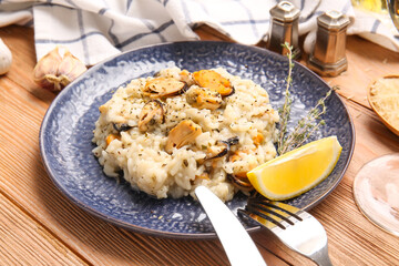 Plate with tasty risotto on wooden background