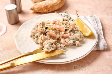 Plate with tasty risotto on color background