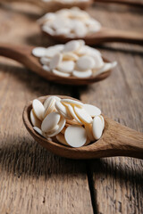 Spoons with chocolate drops on wooden background