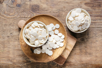 Bowls with chocolate drops on wooden background