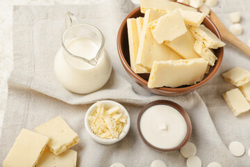 Bowls with white chocolate on fabric background