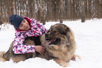 A Happy woman in nature with a large Caucasian watchdog in winter