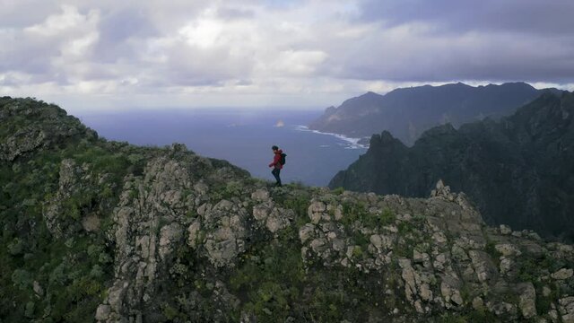 Aerial view of adventurous person walking on the mountain ridge towards Roque de Taborno in wild landscape in Tenerife island.