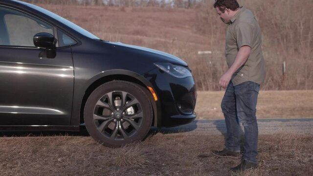 Man upset about a flat tire on side of the interstate.