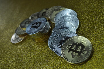 Macro view of gold and silver color shiny coins with Bitcoin symbol
