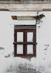 The old closed window on white concrete wall.
