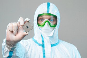 A man in sterile form holds a microprocessor in his hands, close-up. Microchip Design Technology,...
