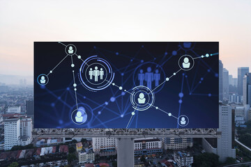Fototapeta premium Glowing Social media icons on billboard over sunset panoramic city view of Kuala Lumpur, Malaysia, Asia. The concept of networking and establishing new connections between people and businesses in KL