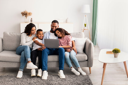 Happy african american family using laptop in living room