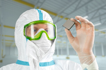 A man in sterile form holds a microprocessor in his hands, close-up. Microchip Design Technology,...