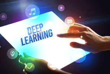 Holding futuristic tablet with DEEP LEARNING inscription, new technology concept