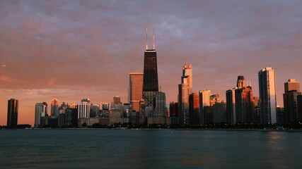 Obraz premium Chicago skyline across Lake Michigan at sunset viewed from North Avenue Beach. Long exposure.