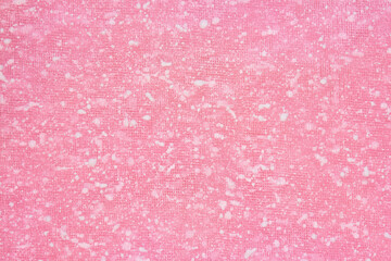 Pink background with white paint spots on a mesh backing