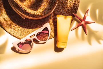 Travel summer accessories and sunscreen with shadow of tropical leaves on color background with copy space, Vacation planning concept