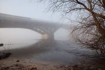 A bridge over a large river.. Fog on the river in early spring