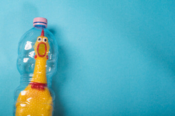 Yellow chicken in a plastic bottle on a blue background.Concept of stop plastic pollution,global warming,recycling plastic,plastic free.