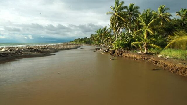River by the jungle along the ocean Costa Rica aerial sunset cloudy day