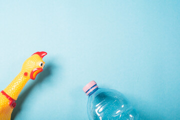 Yellow chicken and plastic bottle on blue backgound.Concept of stop plastic pollution, global warming, recycling plastic, plastic free.