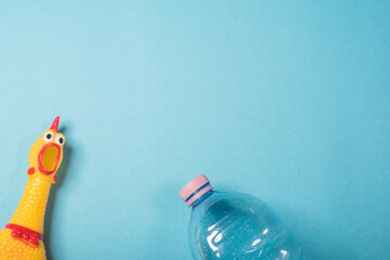Yellow chicken and plastic bottle on blue backgound.Concept of stop plastic pollution, global warming, recycling plastic, plastic free.