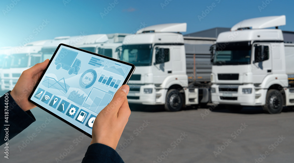 Poster manager with a digital tablet on the background of trucks. fleet management