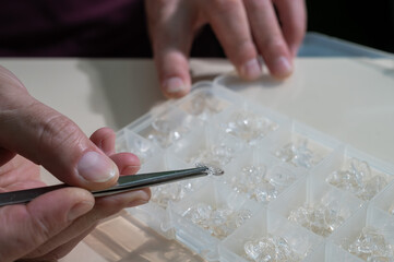 Installation of nose pads in glasses. A male technician repairs broken glasses