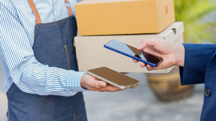 A young Asian deliveryman with a mailbox in a protective uniform, he provides service and the customer receives the front door.