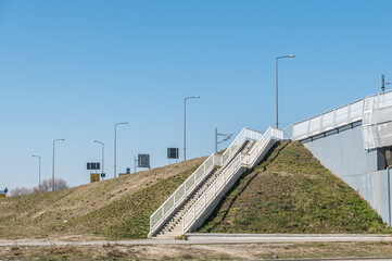 Obraz premium Concrete staircase with a safety fence that leads pedestrians to the bridge