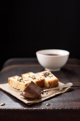 Chocolate caliente en taza blanca con bizcocho en una vieja maleta marrón. Desayuno Español