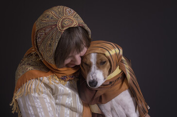 Nice low key portrait of mature Caucasian woman with lovely basenji dog both wearing headscarfs