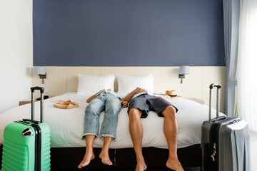 Young tired couple traveler with luggage sleeping on the bed in hotel room