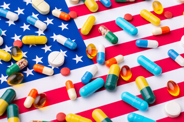 Different pills and tablets on flag of US. Medical system in the United States of America