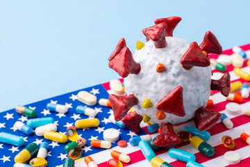 Coronavirus model on flag of the USA with many pills and capsules. Coronavirus pandemic in United States of America