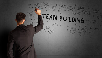 businessman drawing a creative idea sketch with TEAM BUILDING inscription, business strategy concept