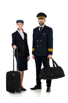Pilot and flight attendant with travel bags standing isolated on white background